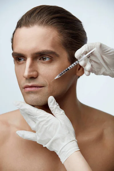 Esteticista que hace la inyección cosmética en la cara masculina del paciente — Foto de Stock