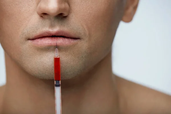 Cara de hombre guapo de primer plano recibiendo inyección, aumento de labios — Foto de Stock