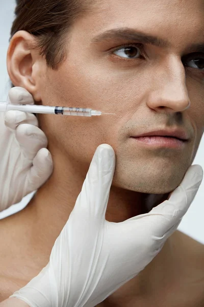 Hombre guapo recibiendo tratamiento de belleza facial, inyecciones de relleno — Foto de Stock