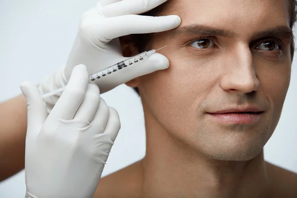 Cosmetologia. Homem bonito recebendo injeções de enchimento na pele do rosto — Fotografia de Stock