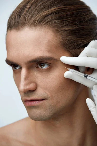 Knappe man ontvangen cosmetische injectie, gezichtsbehandeling — Stockfoto