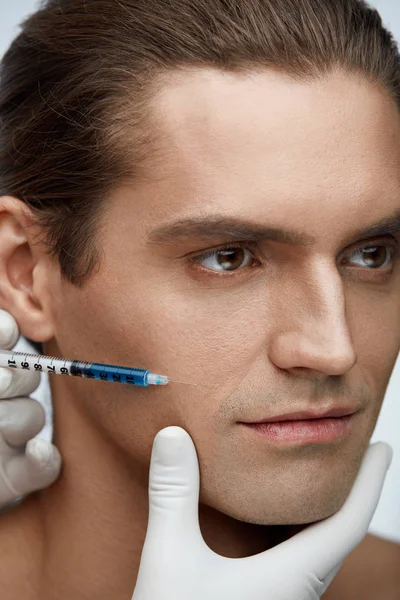 Cirugía plástica. Hombre guapo recibiendo inyecciones en la piel de la cara — Foto de Stock