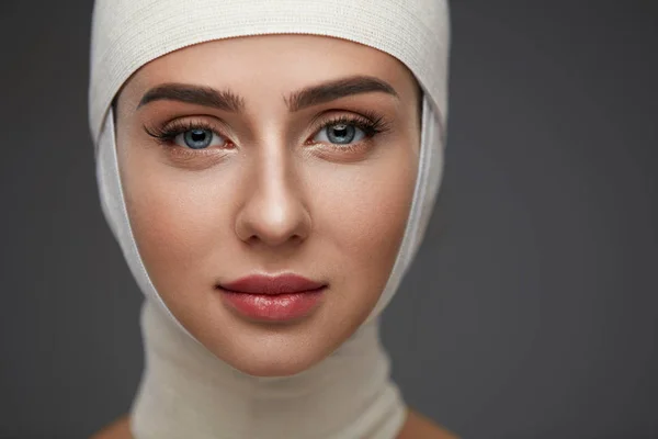 Woman Face With Smooth Soft Skin And Perfect Makeup In Bandages