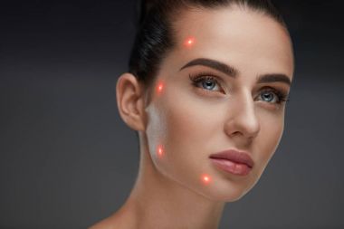 Güzel kadın yüz yüz cilt üzerinde lazer puanla closeup