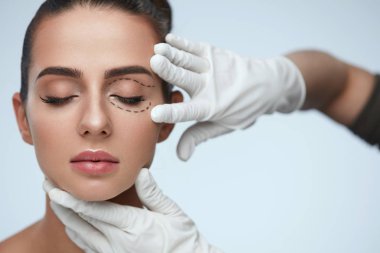 Closeup Of Beautician Hands Touching Young Female Patient Face clipart