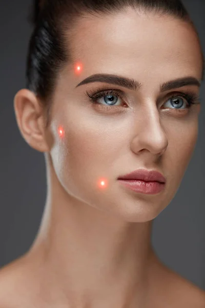 Mulher bonita com pele macia e pontos laser vermelhos na pele — Fotografia de Stock
