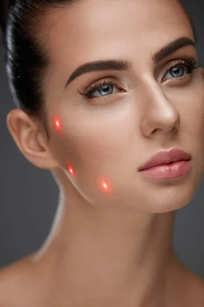 아름 다운 여자 얼굴 얼굴 피부에 레이저 포인트의 근접 촬영 — 스톡 사진