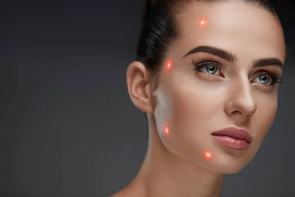 Close-up van de mooie vrouw gezicht met Laser punten op de huid van het gelaat — Stockfoto