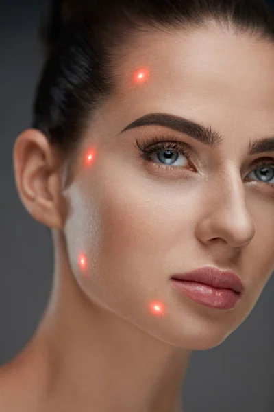 Primo piano di bella donna faccia con punti laser sulla pelle facciale — Foto Stock