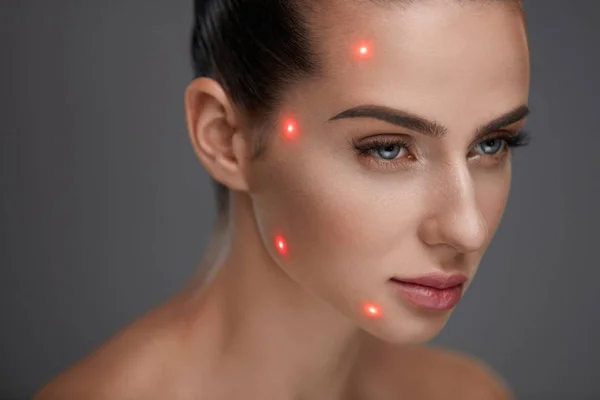 Крупный план красивой женщины с лазерными точками на коже лица — стоковое фото