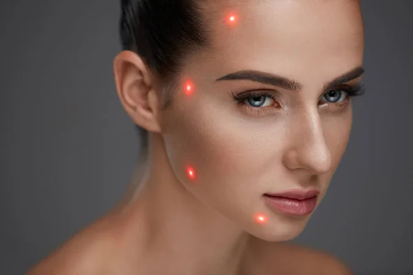 Крупный план красивой женщины с лазерными точками на коже лица — стоковое фото