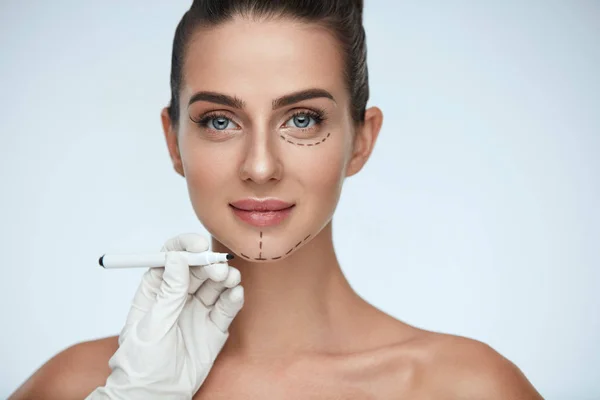 治疗。女人脸上的美容师绘制外科线条 — 图库照片
