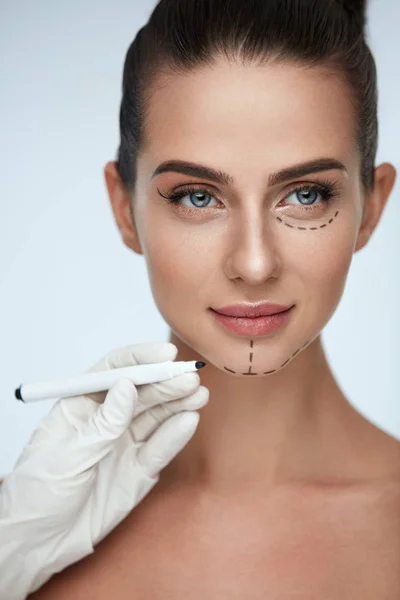 Leczenia. Kosmetyczka rysowanie linii chirurgiczne na twarz kobiety — Zdjęcie stockowe