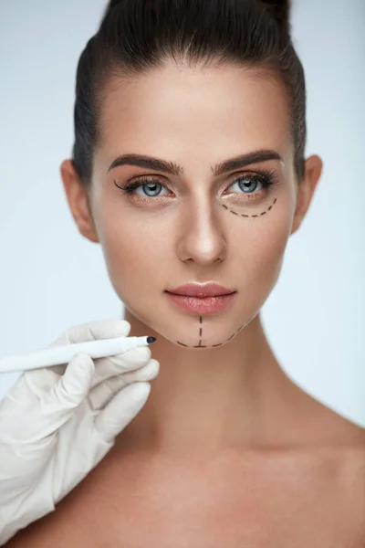治疗。女人脸上的美容师绘制外科线条 — 图库照片