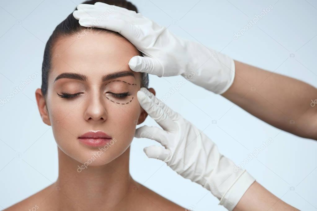 Closeup Of Beautician Hands Touching Young Female Patient Face