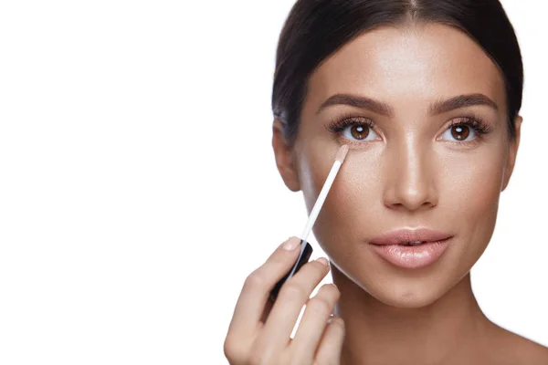 Vacker kvinna applicera Corrector på skönhet ansikte. Makeup — Stockfoto