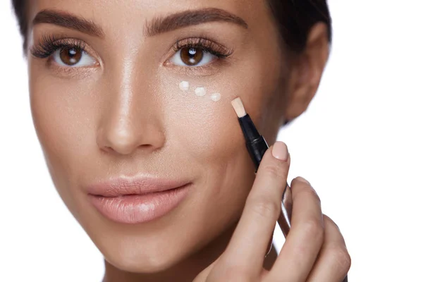 Cosmetica. Mooie vrouw Concealer toepassen op de huid onder de ogen — Stockfoto