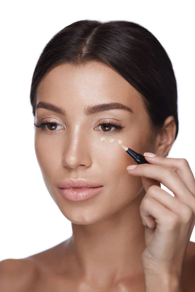 Kosmetik. schöne Frau trägt Concealer auf die Haut unter den Augen auf — Stockfoto