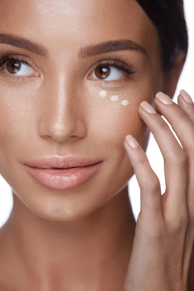 Hermosa mujer que aplica el producto de maquillaje de belleza en la piel de la cara —  Fotos de Stock