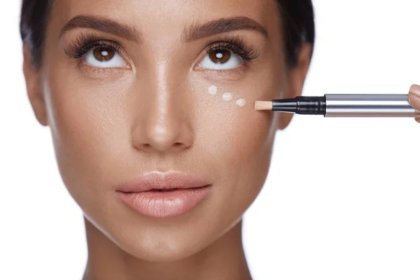 Beauty Woman Face Makeup. feminino aplicando corretor sob os olhos — Fotografia de Stock
