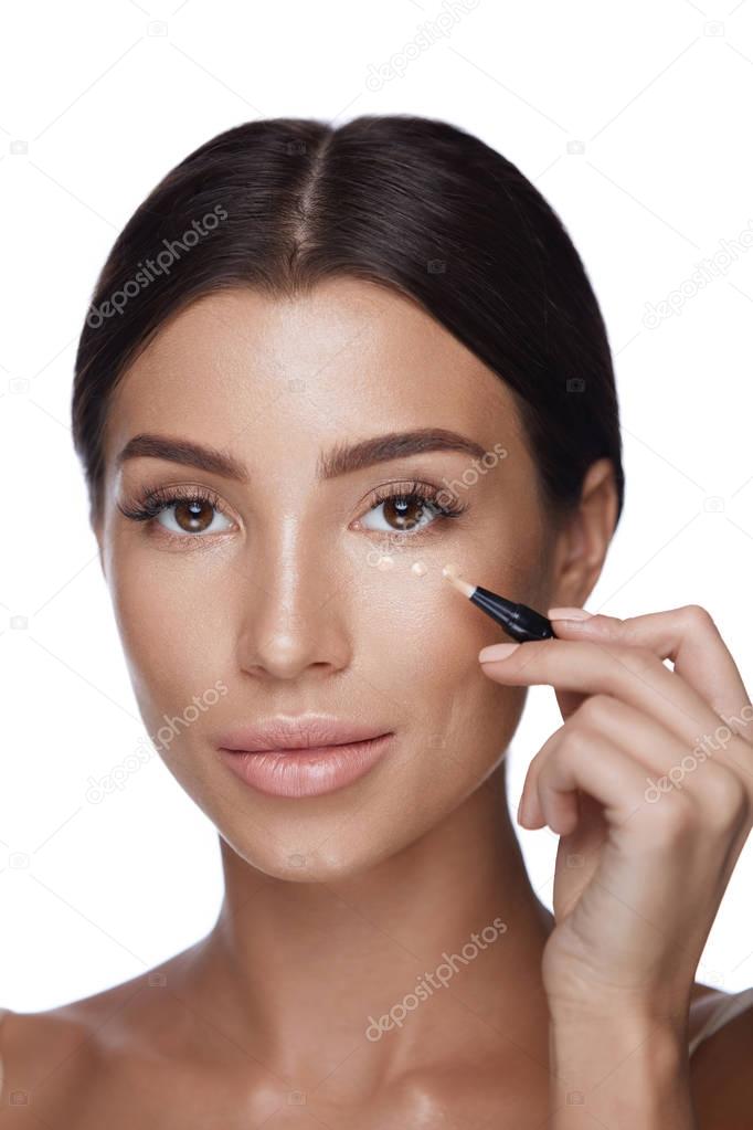 Cosmetics. Beautiful Woman Applying Concealer On Skin Under Eyes