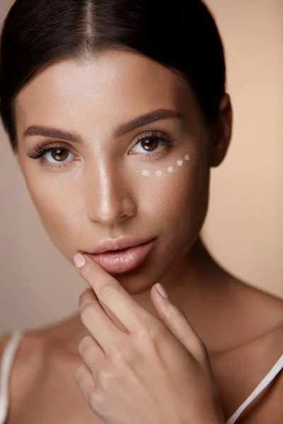 Belleza mujer cara con maquillaje y corrector bajo los ojos —  Fotos de Stock