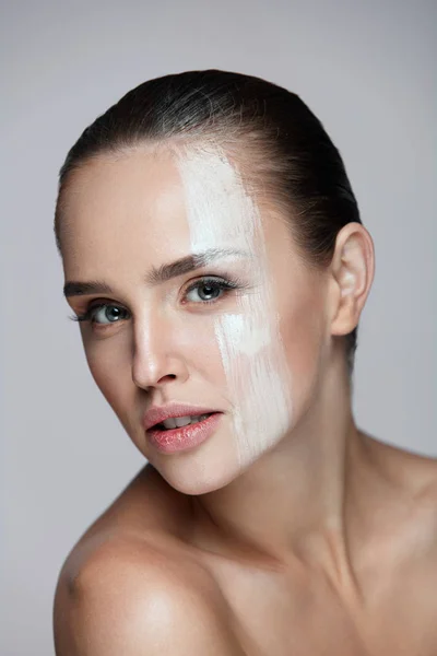 Cosméticos. Mujer sexy con máscara de crema a través de la cara. Cuidado de la piel — Foto de Stock