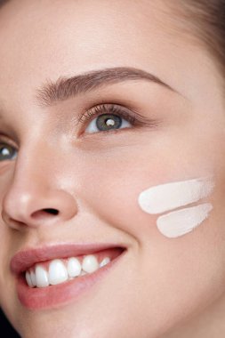 Yüz makyaj. Güzel seksi kadın yüzünde cilt kremi