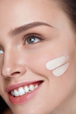 Yüz makyaj. Güzel seksi kadın yüzünde cilt kremi
