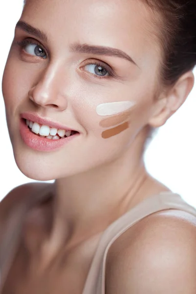 Jonge vrouw met drie tinten van huid crème Tone op gezicht — Stockfoto