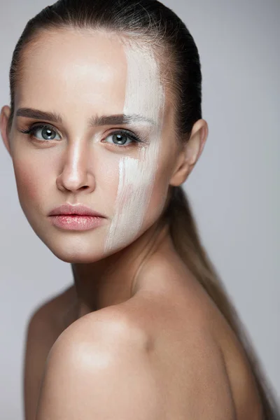 Cosméticos. Mujer sexy con máscara de crema a través de la cara. Cuidado de la piel — Foto de Stock