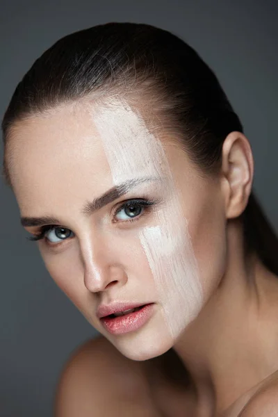 Макияж лица. Сексуальная женщина в кремовой маске на коже лица — стоковое фото