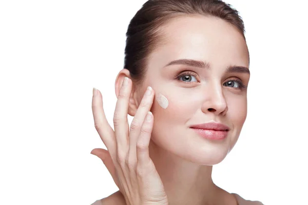 Cosméticos. Hermosa chica aplicando crema en la cara. Maquillaje de belleza — Foto de Stock