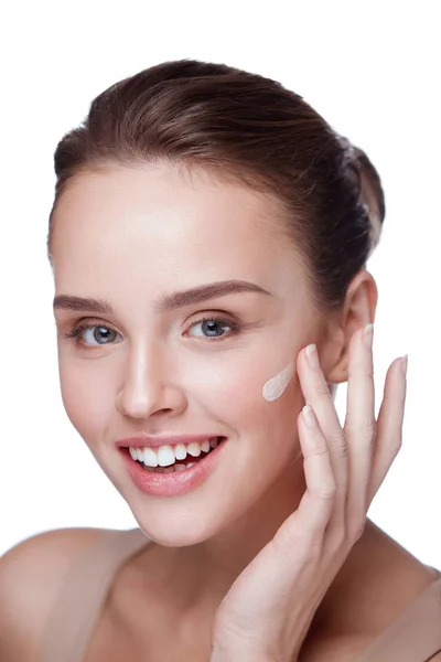 Cosméticos. Hermosa chica aplicando crema en la cara. Maquillaje de belleza — Foto de Stock