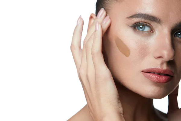Schönheitskosmetik. schöne Frau macht Make-up-Produkt im Gesicht — Stockfoto
