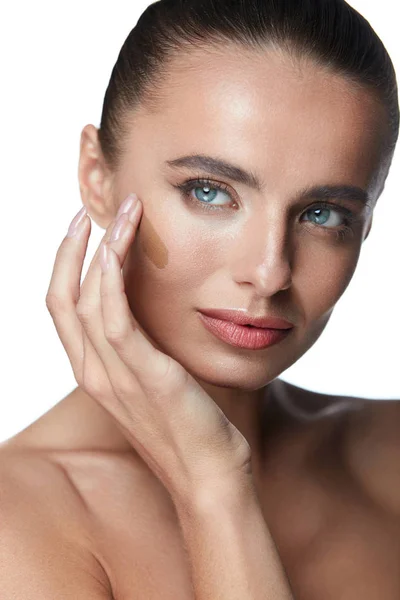 Cuidados faciais. Mulher sexy aplicando Dark Foundation no rosto perfeito — Fotografia de Stock