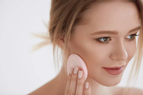 Gesicht Schönheit. Mädchen mit kosmetischen Puff setzen trockene Grundlage — Stockfoto