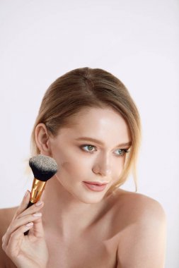 Güzellik makyaj. Güzel genç kadın modeli kozmetik fırça ile