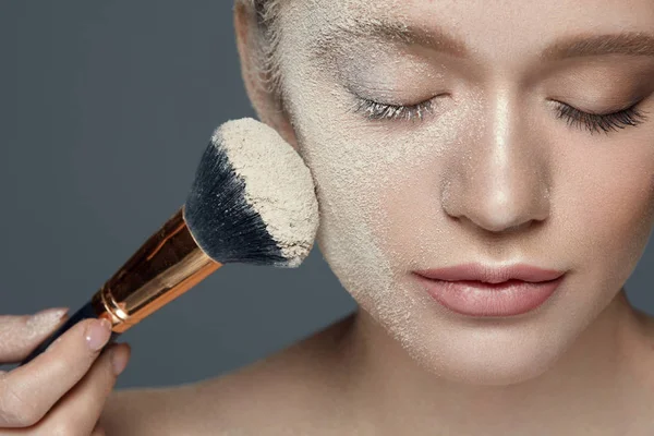 Kosmetické make-up. Krásná žena s práškem na obličej a štětec — Stock fotografie