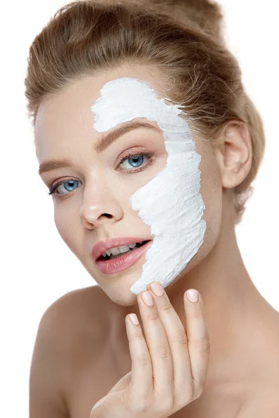 Cuidado com a pele. Jovem mulher aplicando máscara branca no rosto. Cosméticos — Fotografia de Stock