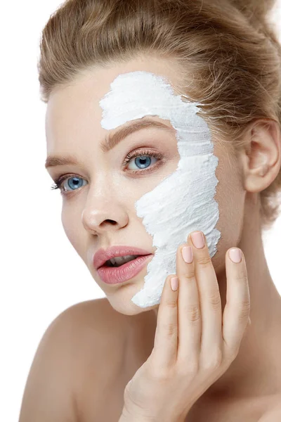 Cuidado com a pele. Jovem mulher aplicando máscara branca no rosto. Cosméticos — Fotografia de Stock