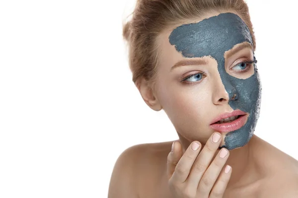 Уход за лицом красотки. Женщина с натуральным макияжем наносит маску из глины — стоковое фото