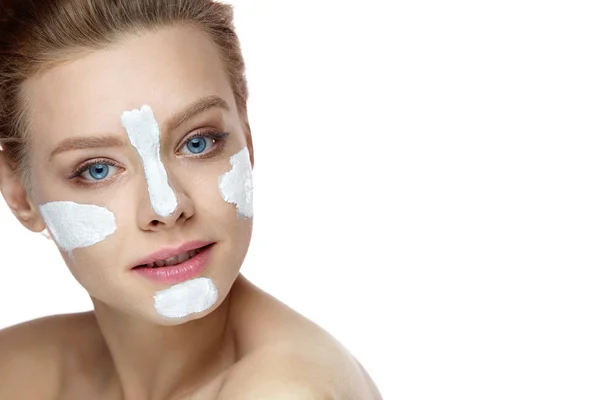 Het gezicht van de schoonheid. Mooie vrouw met wit masker op huid — Stockfoto