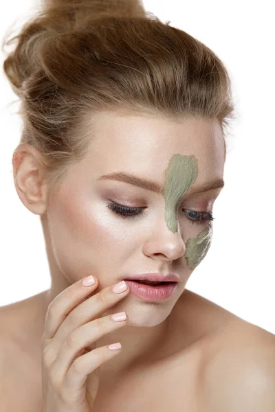 Skönhet kosmetika. Kvinna med lermask ränder på hud i ansiktet — Stockfoto