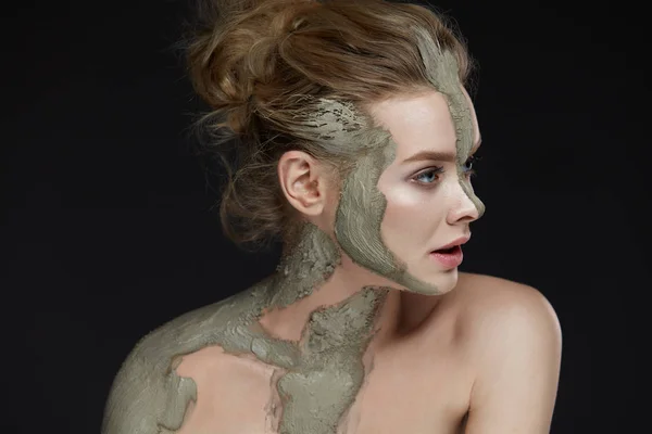 Tratamiento de belleza. Mujer con máscara de arcilla cosmética en la piel —  Fotos de Stock