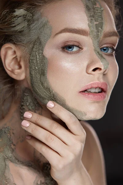 Procedimiento cosmético. Mujer con máscara de barro en la cara y el cuerpo — Foto de Stock