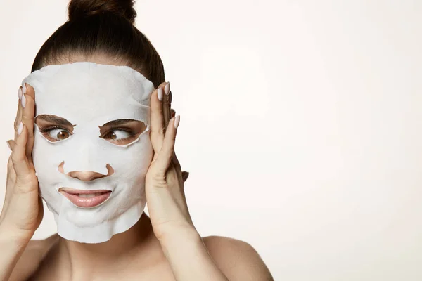 Tratamiento de la piel. Mujer joven poniendo máscara cosmética en la piel facial —  Fotos de Stock