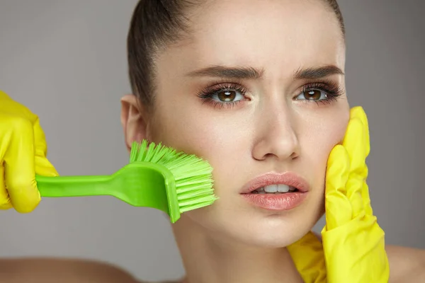 Mujer con cepillo en la mano exfoliante, frotando la piel facial —  Fotos de Stock