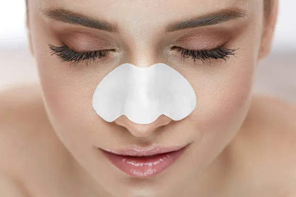 Vacker kvinna ansikte med hud Care plåster på näsan — Stockfoto