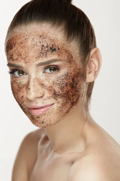Cuidado facial. Mujer joven con exfoliante de café en la piel facial —  Fotos de Stock